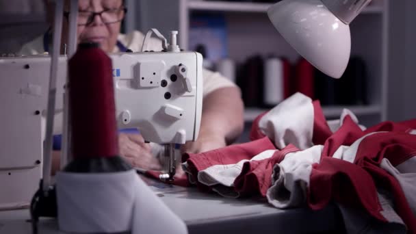 当她把美国国旗拼凑在一起的时候 缝纫机上的女人正在把美国国旗缝起来 — 图库视频影像