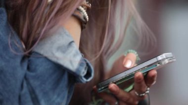 O kafasını ellerinin üzerinde tek başına oturmak dayanıyor gibi telefon swiping adımlar üzerinde oturan lise teen.