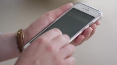 O telefonda türleri olarak bir yolculuk almak için Uber uygulamasını kullanarak kadın görünümü.