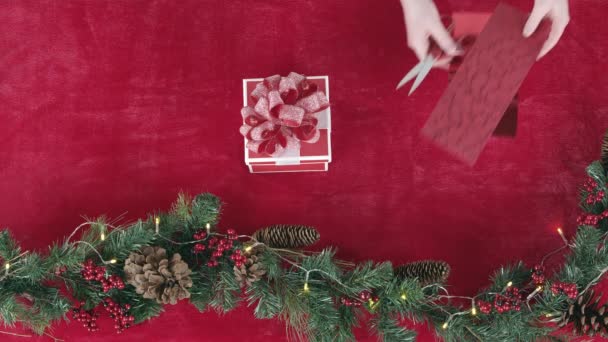 休日のディスプレイのためのガーランド花輪の横にテーブルの上に置かれているクリスマスプレゼント — ストック動画