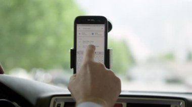 Yön-e doğru hedef almak için telefonu arabada haritalar kullanan kişi.