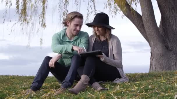 Young Caucasian Couple Using Ipad Big Tree — 비디오