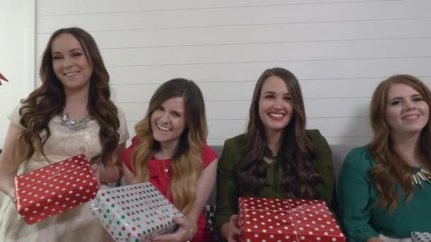 Όμορφα Κορίτσια Κάθεται Στον Καναπέ Και Δείχνει Χριστουγεννιάτικα Δώρα — Αρχείο Βίντεο
