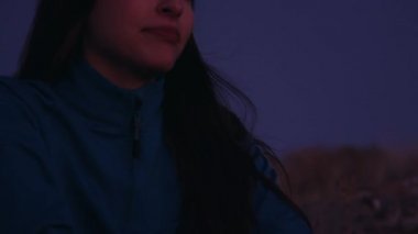 Genç güzel kız dağlarda oturuyor ve düşünüyor.
