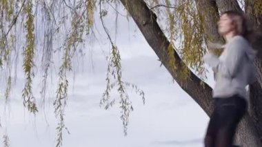 Beyaz kadın güzel ağacın yanında koşuyor