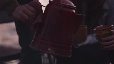 Gençlerin grup açık ateşte su ısıtıcıçay ısıtıyor