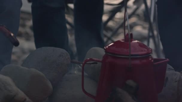 一群青少年在室外燃烧的火上 在水壶里加热茶水 — 图库视频影像