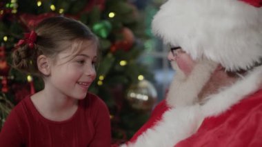 Küçük kız Noel Baba'yı ziyaret ediyor.
