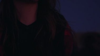 Genç güzel kız dağlarda oturuyor ve düşünüyor.