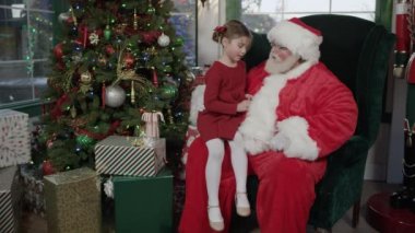 Küçük kız Noel Baba'yı ziyaret ediyor.