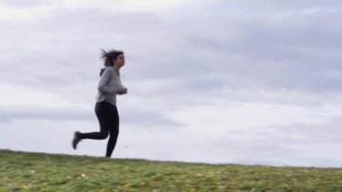 Beyaz kadın güzel ağacın yanında koşuyor