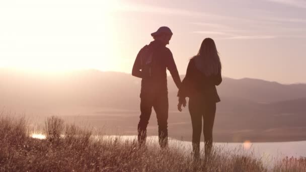 Νεαρό Ερωτευμένο Ζευγάρι Αναπαύεται Στα Βουνά Στο Όμορφο Ηλιοβασίλεμα — Αρχείο Βίντεο