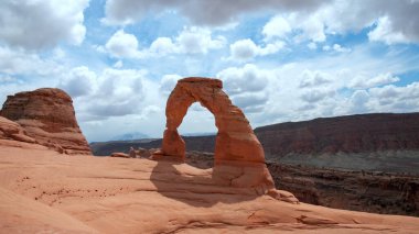 View of Delicate Arch against clouds in the sky in Arches National Park. clipart