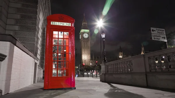 Big Ben 'in gece Londra' da kırmızı bir telefon kulübesinin arkasında görüntüsü..