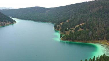 Montana 'daki Cliff Gölü' nün üzerinde uçarak sudaki su renklerini ve renkli kıyı şeridini seyrediyor..