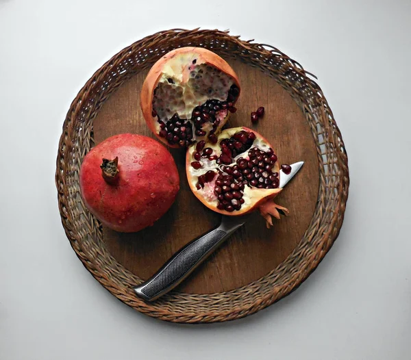 Çatlama ve ahşap plaka üzerinde çelik bıçak ile bölme nar