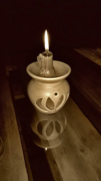 Cam yüzey üzerinde mum mum. Sepya. Koyu arka plan.