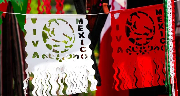 İpe asılı iki Meksika bayrağı. Biri kırmızı ve beyaz, diğeri beyaz ve kırmızı.
