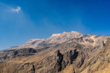 Arka planda açık mavi gökyüzü olan bir dağ sırası. Dağlar karla kaplı ve gökyüzü parlak ve berrak. Iztacihuatl popocatepetl Yanardağ Meksika,