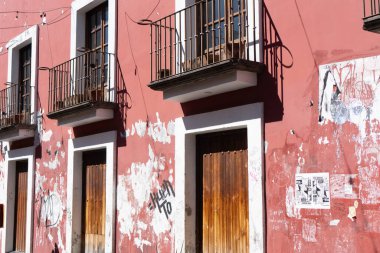 A building with a lot of graffiti on it. The building has a lot of windows and a balcony. City of Puebla, Mexico, crafts
