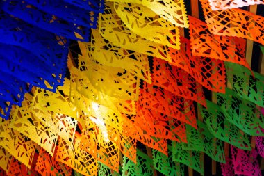Hareket ve enerji hissi yaratacak şekilde düzenlenmiş renkli kağıt bayrakların canlı ve canlı bir görüntüsü. Meksika 'da Ölüler Günü kutlaması, papel picado el sanatları, adaklar, La Catrina