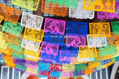 Tavandan renkli bir kağıt fener gösterisi sarkıyor. Fenerlerin renkleri ve boyutları farklıdır. Meksika 'da Ölüler Günü kutlaması, papel picado el sanatları, adaklar, La Catrina