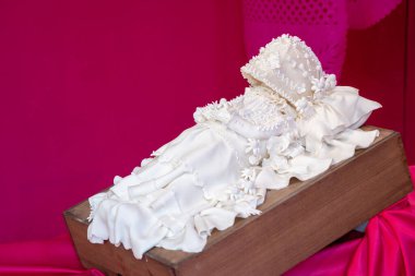 Bir bebek beyaz bir elbise ve beyaz bir şapka giyer ve ahşap bir kutuya yerleştirilir. Meksika 'da Ölüler Günü kutlaması, papel picado el sanatları, adaklar, La Catrina