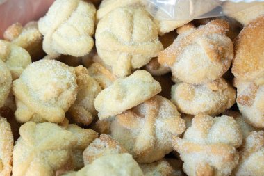 Beyaz kremalı bir paket şekerli kurabiye. Kurabiyeler küçük ve yuvarlak. Şekerle kaplanmışlar. Meksika 'da Ölüler Günü kutlaması, papel picado el sanatları, adaklar, La Catrina