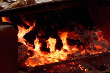 Şöminede bir ateş yanıyor, alevler şöminenin üstüne ulaşıyor. Ateş sıcak ve parlak, sıcak ve sıcak bir atmosfer yaratıyor. Meksika, Meksika.