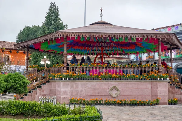 A colorful pavilion with a lot of flowers and plants. The pavilion is surrounded by a garden. Mexico, zacatlan de las manzanas, puebla, day of the dead mexican tradition