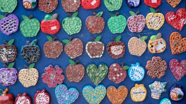 A blue background with many different colored apples on it. The apples are all different shapes and sizes. Mexico, zacatlan de las manzanas, puebla, day of the dead mexican tradition
