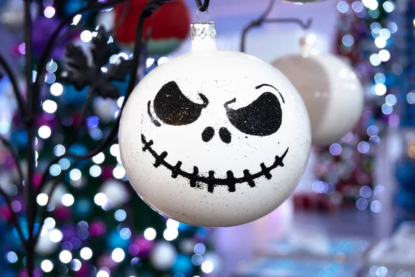 Kızgın gibi görünen, üzerinde yüzü olan beyaz bir Noel süsü. Yüzü kırmızı burunlu siyah beyaz. Meksika, Puebla, Chignahuapan, renkli tasarımlı dekoratif Noel baloları