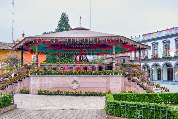A colorful pavilion with a large number of flowers and plants. The pavilion is surrounded by a garden. Mexico, zacatlan de las manzanas, puebla, day of the dead mexican tradition