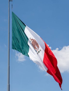 Yeşil arka planı ve üzerinde kırmızı-beyaz kartal olan bir bayrak. Bayrak gökyüzünde dalgalanıyor. Meksika 'da Bağımsızlık Günü' nü kutlamak için bir madalya, Zocalo.