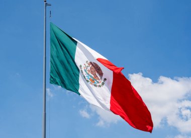 Gökyüzünde kırmızı ve yeşil desenli bir bayrak dalgalanıyor. Bayrak Meksika 'dan geldi ve rüzgarda dalgalanıyor. Meksika 'da Bağımsızlık Günü' nü kutlamak için bir madalya, Zocalo.