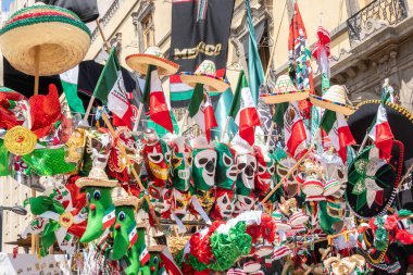 A display of Mexican hats and flags. The flags are in various colors and sizes, and the hats are also in different shapes and sizes. Decoration to celebrate Independence Day in Mexico, zocalo