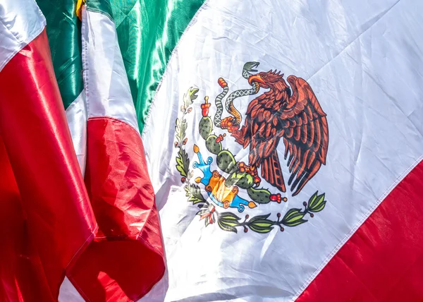 Kırmızı, beyaz ve yeşil desenli bir bayrak. Bayrağın üstünde bir kartal var ve elinde bir yılan tutuyor. Meksika 'da Bağımsızlık Günü' nü kutlamak için bir madalya, Zocalo.