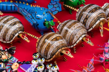 A collection of small figurines, including turtles and penguins, are displayed on a red table. Historic center of Queretaro City, decorations and traditions to celebrate Mexico's Independence Day, colonial architecture, alleys and facades