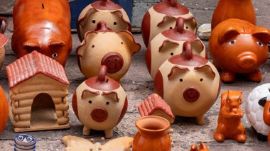 A table is filled with a variety of piggy banks and other figurines, including a cow, a sheep, and a. Historic center of Queretaro City, decorations and traditions to celebrate Mexico's Independence Day, colonial architecture, alleys and facades