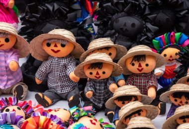 A collection of dolls with straw hats and colorful clothing. The dolls are arranged in a row. Historic center of Queretaro City, decorations and traditions to celebrate Mexico's Independence Day, colonial architecture, alleys and facades