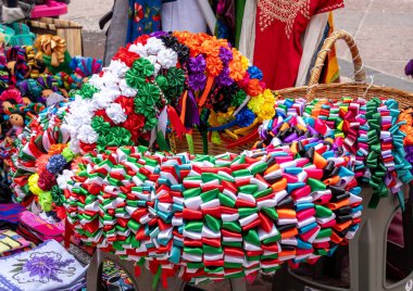 A vibrant and colorful wreath made of ribbons is on display on a table. Historic center of Queretaro City, decorations and traditions to celebrate Mexico's Independence Day, colonial architecture, alleys and facades