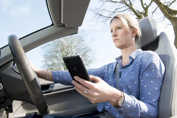 Distracted driving, woman texting while driving