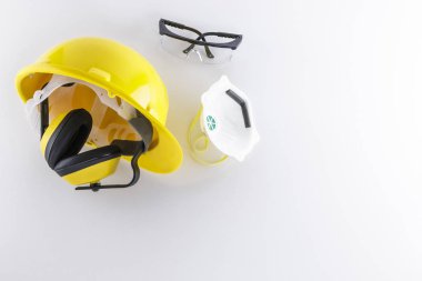 Baret, kulak muffs, koruyucu gözlük ve yüz maskesi kopya alanı ile beyaz bir arka plan üzerinde de dahil olmak üzere inşaat koruyucu giyim