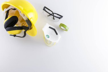 Baret, kulak muffs, koruyucu gözlük, yüz maskesi ve yapışkan bant kopya alanı ile beyaz bir arka plan üzerinde de dahil olmak üzere inşaat emniyet dişli