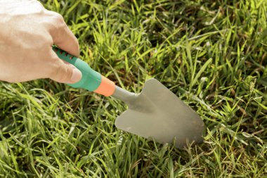 Toprak çimenli bir yama aşağı Bahçe bir mala shoving el