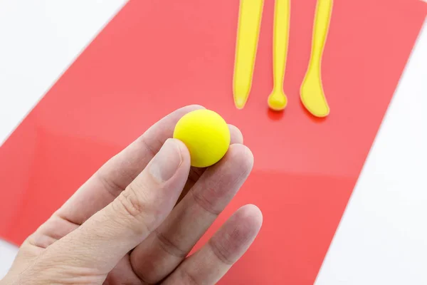 Mão Segurando Uma Bola Barro Macio Amarelo Com Ferramentas Artesanato — Fotografia de Stock