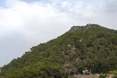 Arka planda bulutlu mavi gökyüzü ile dağ zirvesi