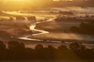 Haze and sun rays over the Ouse River clipart