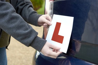 Bir arabanın arkasına yerleştirilen öğrenci sürücü 'L' işareti