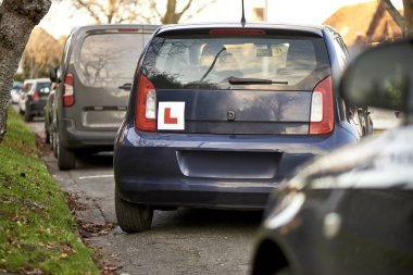 Mavi Hatchback Araba Yanında Öğrenci Sürücü İşareti Park ile 